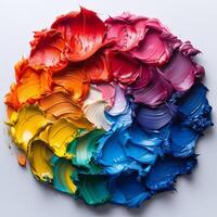 A circle featuring various colors of paint positioned on a white surface photo
