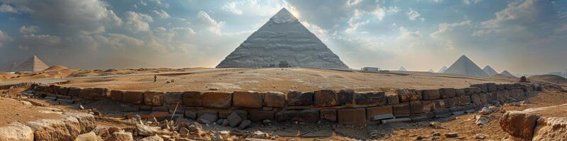 A large pyramid in the middle of desert with other pyramids in background photo