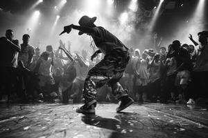 Black and white photo man dancing in spotlight in front of large crowd
