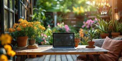 A laptop computer is placed on a wooden table outdoors in a garden setting photo