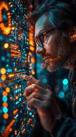 A man with glasses gazing at a computer in darkness photo