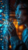 A man in glasses looks out a window with blue lights behind photo