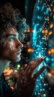 Man with curly hair looking at screen emitting blue light photo