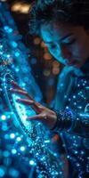 A woman is interacting with a luminous object using her hand photo