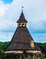 spire of an ancient tower with a wooden roof photo