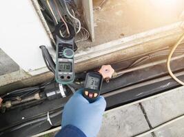 Checking and measuring temperature using a thermo gun in the refrigeration system in HVAC air conditioning. Refrigeration check using thermo gun with concept professional hvac service. photo