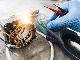 Fan motor winding repair process, concept of checking and repairing motor windings using a tester. photo