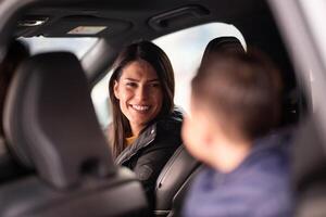 In the nighttime hours, a happy family enjoys playful moments together inside a car as they journey on a nocturnal road trip, illuminated by the glow of headlights and filled with laughter and joy photo