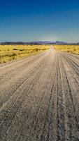 Desert gravel road with vanishing point displaying the way forward. Smartphone format or vertical banner. photo