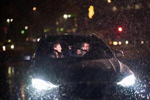 In the midst of a nighttime journey, a happy family enjoys playful moments inside a car as they travel through rainy weather, illuminated by the glow of headlights, laughter, and bonding photo