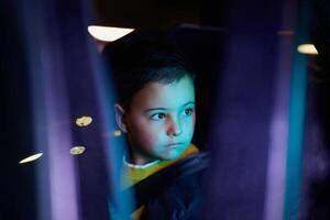 A young boy enjoys a car ride, captured through the window, as he observes the passing scenery. photo