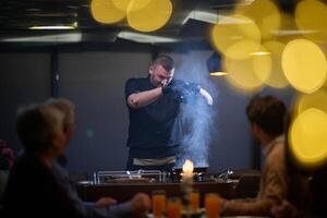 In a restaurant setting, a professional chef presents a sizzling steak cooked over an open flame, while an European Muslim family eagerly awaits their iftar meal during the holy month of Ramadan photo