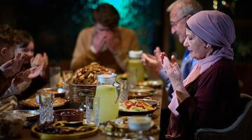 In a modern restaurant setting, a European Islamic family comes together for iftar during Ramadan, engaging in prayer before the meal, uniting tradition and contemporary practices in a celebration of photo