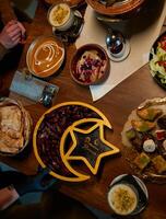 In this captivating aerial view, delicious food adorned with Ramadan decorations, including dates and meat, awaits the arrival of an European Islamic family, promising a festive and flavorful iftar photo