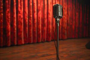 A close up of a microphone on a stand in front of a red curtain photo