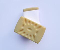 Yellow soap with blank label with color on gray background photo