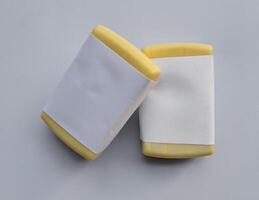 Yellow soap with blank label with color on gray background photo