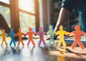 Paper Chain Man holding hands, at a bright and clean office desk, suitable for relationships and teamwork photo