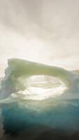 A large iceberg floating in the middle of a body of water video