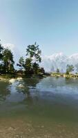 A lake surrounded by trees and rocks with a mountain in the background video