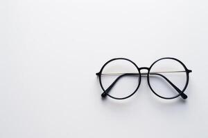 Minimalistic composition of round black eyeglasses on white background photo
