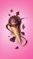 Chocolate ice cream waffle cone with pieces of chocolate on the air. Concept of levitation. Pink background 4k animation banner vertical video