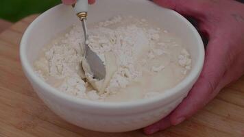 kneading dough in a white plate, making dough against the background of a table video