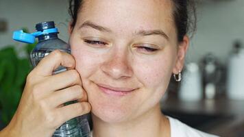 Young woman with bottle with stationary plastic cap. The new design means the cap remains attached to the bottle after opening, making the entire package easier to collect and recycle. video