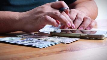 Male Hands Counting a Stack of 100 Dollar Bills on Blurred Money Background. Stack of banknotes in 10000 american dollars currency strap for hundreds. Investments in cryptocurrency. Capital. Wealth. video