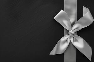 Flat Lay of White Ribbon Bow on Black Background for Elegant Decoration photo