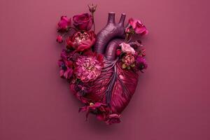 Burgundy flowers forming anatomical heart on dark pink background. Artistic concept. photo
