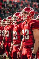 Football players in red uniforms stand on the field photo