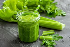 A jar of celery juice next to some celery stalks photo