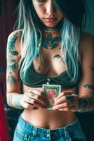 Woman with tattoos holding a playing card in her hands photo