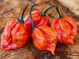 Three hot peppers on a wooden board on a table photo