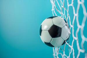 A soccer ball in the net with a blue background photo