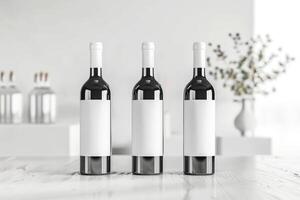 Three wine bottles with white labels on table photo