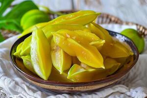 A bowl of star fruit on a table photo