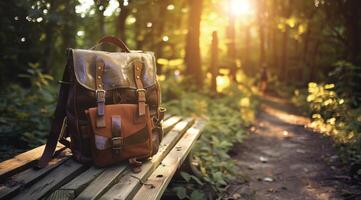 Vintage Leather Backpack on Wooden Bench in Sunlit Forest Path photo