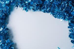 Blue tinsel on a white background with copy space for text. photo