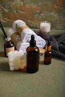 Spa and Wellness Essentials with Amber Dropper Bottles, Towels, and Candles photo