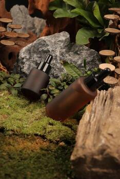Matte Amber Dropper Bottles with Black Caps in Natural Moss and Stone Setting photo