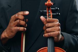 Close up portrait of man in suit playing violin with bow in hand, music and art concept photo