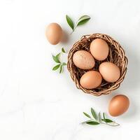 Chicken eggs in basket on white background. Top view, flat lay photo