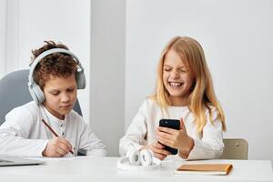contento hermanos haciendo en línea deberes juntos a hogar un chico y un niña sentado a un mesa en su foto
