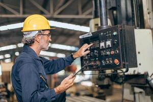 senior professional engineer working control operate program CNC milling machine in heavy industry factory photo