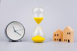 Hourglass on gray background, time and running out of time in studio photo style