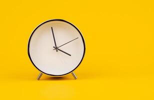 Time and work, the clock stops, the minute hand stops moving, a photo of a clock on a yellow background.