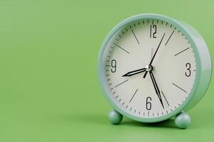 Time, standing still, time hand, photo of a moving clock on a green background, time concept.