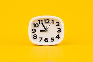 Clock on a yellow background, working with time and planning life, studio photo